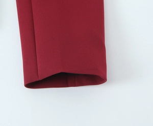 Detail shot of burgundy blazer cuff showing plain weave fabric texture and stitching