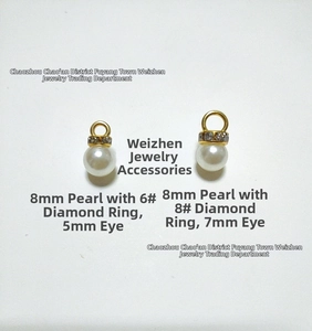 Macro detail of 8mm ABS pearls with gold rhinestone spacers and metal hanging loops