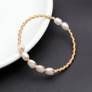 Detail of hand-woven gold bracelet featuring six natural white freshwater pearls