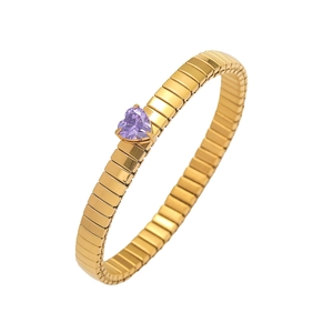 Detail of a golden Tubogas stretch bracelet with a purple heart-shaped gemstone