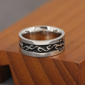 Men's vintage steel ring with black wave totem engraving on a wooden pedestal
