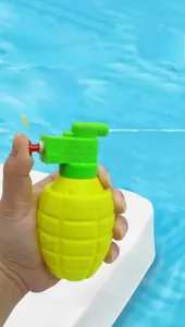 Detail showing hand holding grenade-shaped water gun by the swimming pool