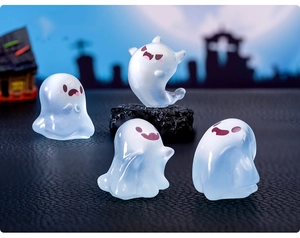 Detailed view of four glow-in-the-dark miniature ghost figurines for Halloween decor