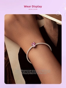 Gros plan d'un bracelet en argent S925 avec un pendentif nœud violet sur un poignet de femme