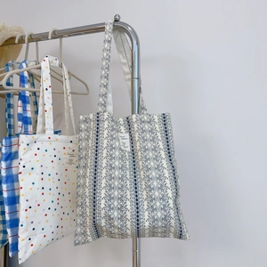 Canvas tote bags in blue plaid, polka dot, and floral patterns with long shoulder straps