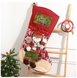 Detail of red Christmas stockings with 3D snowman doll hanging on a wooden ladder