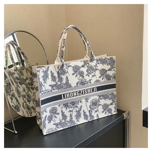 Detailed view of blue floral porcelain pattern and LIHONGZISHEJI text on felt tote bag