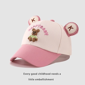 Detail of a pink and beige baseball cap featuring a cute 3D teddy bear and embroidery