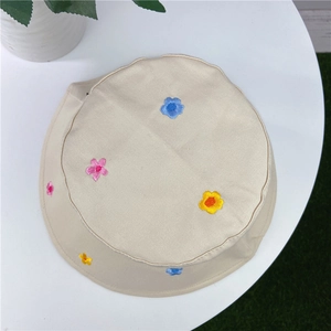 Detail of colorful floral embroidery on a beige cotton bucket hat for women