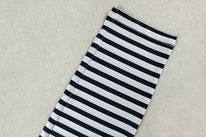 Macro view of black and white striped high-density fabric with double-stitched hem detail