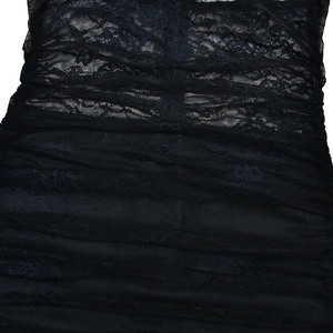 Close-up of black floral lace mesh fabric with detailed pleated texture on the dress