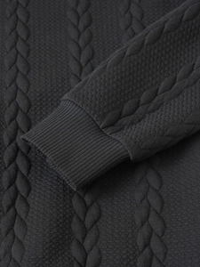 Macro detail showing the ribbed cuffs and 3D jacquard texture of the knitted sweater