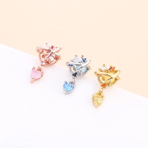 Macro shot of heart-shaped zircon planet pendants in rose gold, silver, and gold finishes