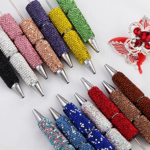 Disposizione dettagliata di penne con perline di strass colorate in varie tonalità su bianco