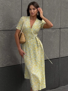 Detailed close-up of yellow floral wrap dress featuring V-neck and puff sleeves