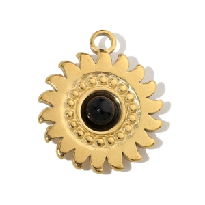 Macro detail of sunburst stainless steel pendant with central black stone inlay