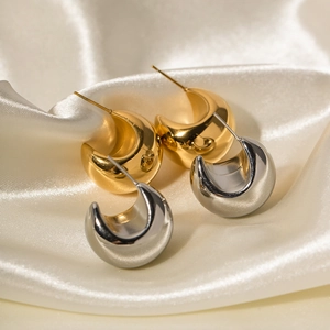 Polished 18k gold and silver thick C-shape hoop earrings on soft satin background