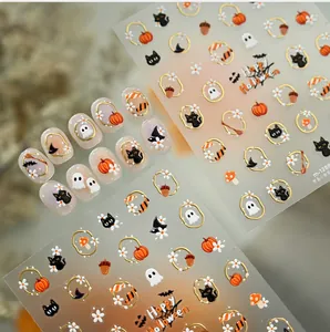 Close-up of Halloween nail stickers with gold embossed pumpkin, ghost and black cat motifs