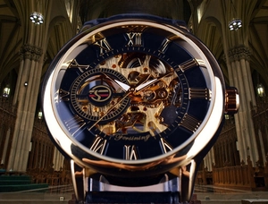 Macro view of skeleton mechanical watch with golden gears and 3D blue Roman numeral dial