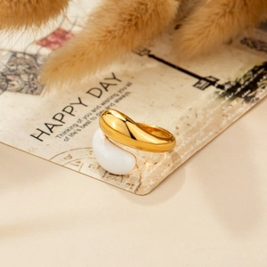 Minimalist gold and white stainless steel rings on a gift card with dried flower decor