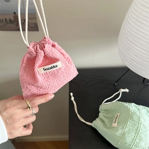 Detail of pink and green seersucker drawstring pouches with Sozakka brand labels
