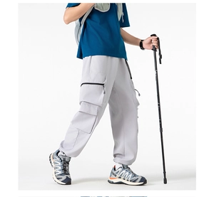 Dettaglio dei pantaloni cargo grigio chiaro con tasche a zip e orlo con coulisse