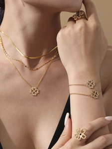 Close-up of gold clover jewelry set with sparkling crystals worn by a model