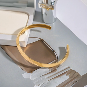 Detailed view of a minimalist 18K gold-plated stainless steel open cuff bracelet