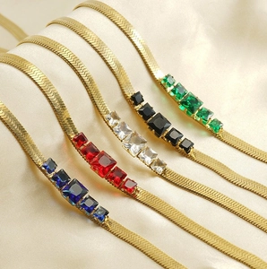 Detail of 18k gold snake chain necklaces with colorful square zircon gemstone inlays