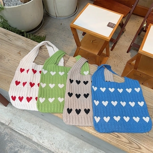 Detailed knit texture and heart pattern of the tote bags in four color options