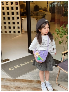 Detail of purple knitted child crossbody bag with pink flower and pearl button detail