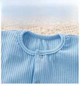 Close-up of baby romper neckline featuring soft ribbed cotton and light blue snap buttons