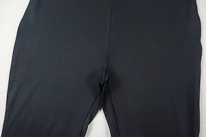 Close-up of durable stitching and elastic knit fabric on black slim-fit jumpsuit crotch