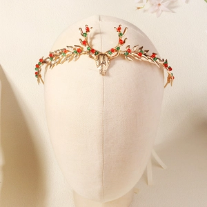 Detail of Christmas reindeer headband featuring golden antlers with red and green rhinestones