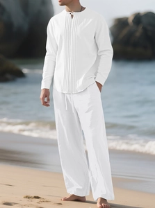 Détail d'une chemise henley en coton lin blanc et d'un pantalon à cordon sur une plage