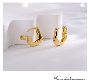 Macro detail of gold plated irregular earrings with micro inlaid zirconium accents