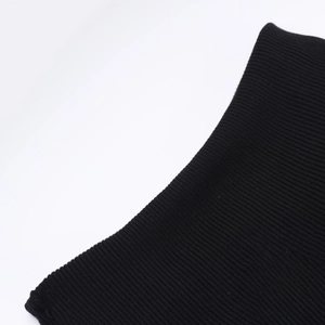 Detailansicht des schwarzen Rippstrickgewebes und der hochwertigen Textur am Kleid