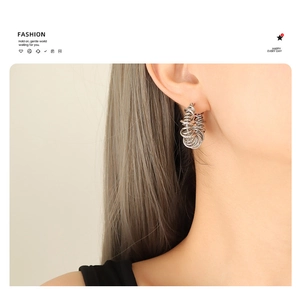 Close-up of geometric silver multi-layer coiled hoop earrings on female model