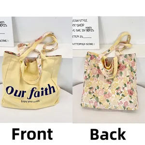 Close-up of double-sided canvas tote with floral patterns and slogan print
