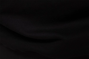 Close-up of black knitted fabric texture and soft cotton fibers on a casual sweatshirt