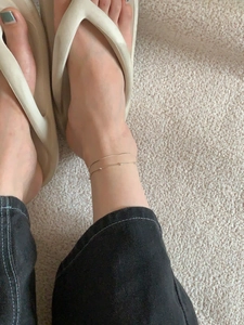 Close-up of minimalist double-layer gold snake chain anklet with beads on ankle