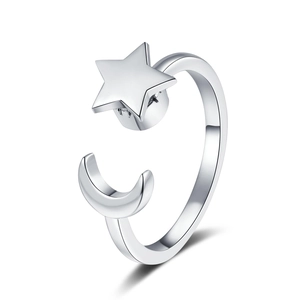 Macro shot of silver open ring with 3D star and moon charms on white background
