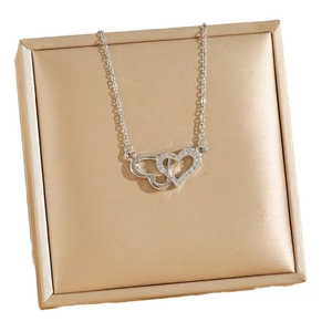 Elegant silver titanium steel necklace with double heart pendants on a gold jewelry box