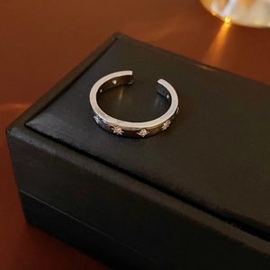 Détail d'une bague étoile argentée sur boîte à bijoux noire avec design ouvert réglable