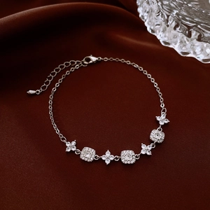 Detail of 18K gold-plated adjustable bracelet with square and floral zircon pendants