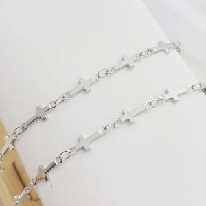Detailed view of silver metal cross chain wrapped on a white display stand for DIY jewelry