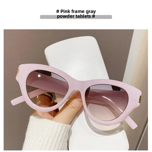 Close-up of pink cat eye sunglasses with thick frames and gradient pink-grey lenses