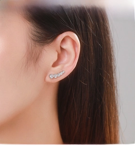 Macro shot of silver ear climbers with five graduated round-cut sparkling cubic zirconia stones