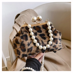 Detail of leopard print faux fur handbag with pearl chain and elegant metal clasp closure