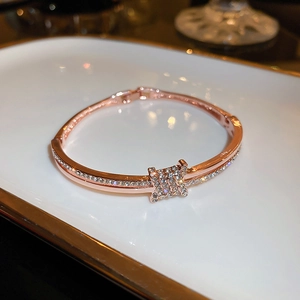 Macro view of rose gold plated pave-set zircon bracelet with twisted knot design